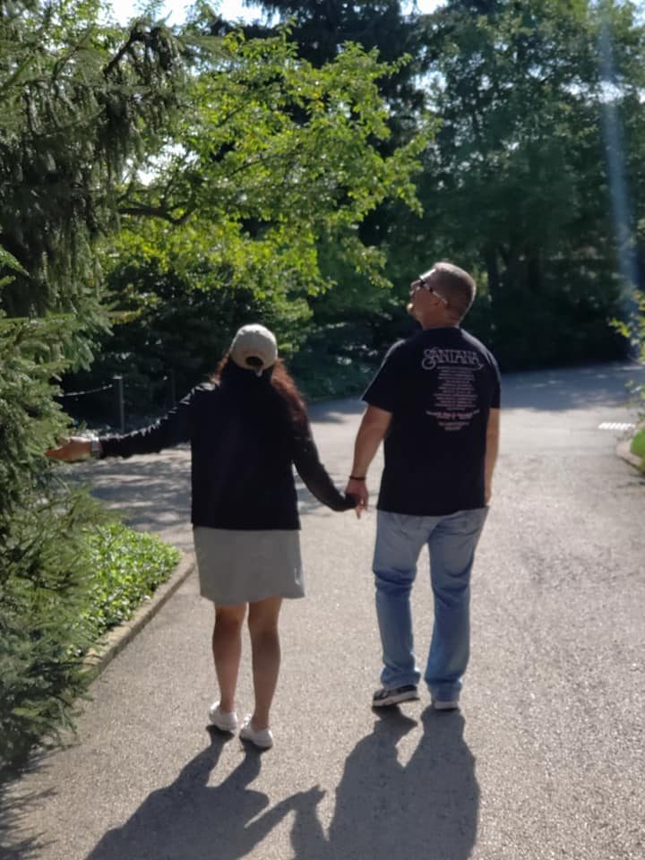 Larence and Ruthy walking hand in hand through a botanical garden